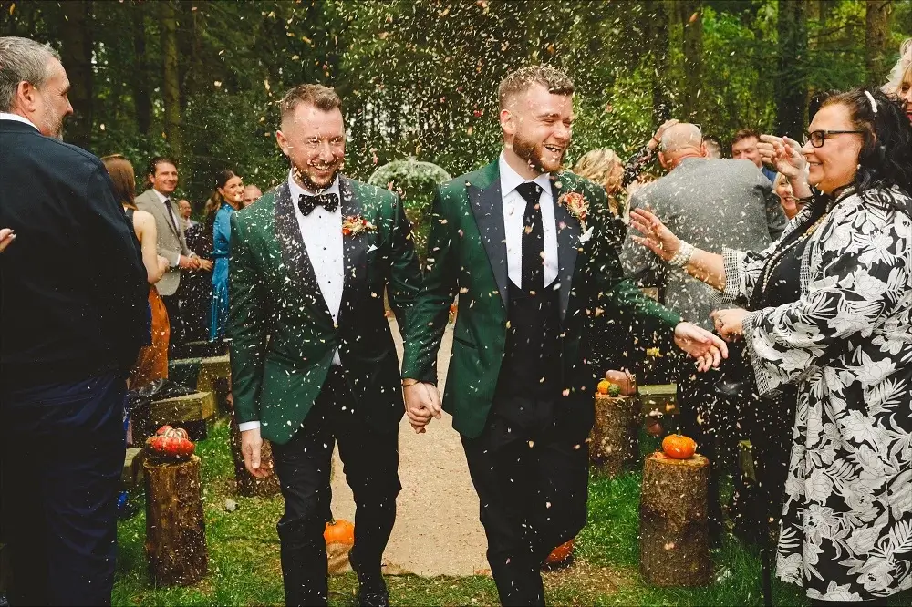 Grooms walking down aisle with confetti